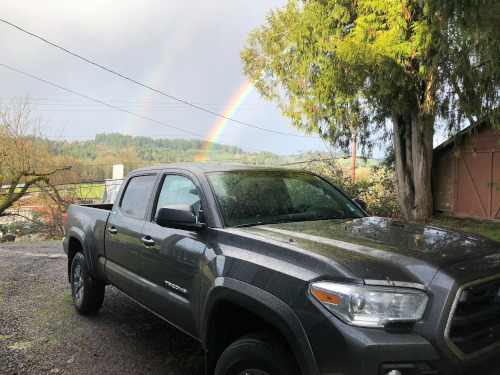 Truck with double rainbow in background