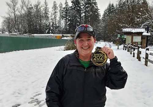 Me holding my medal while standing in the snow